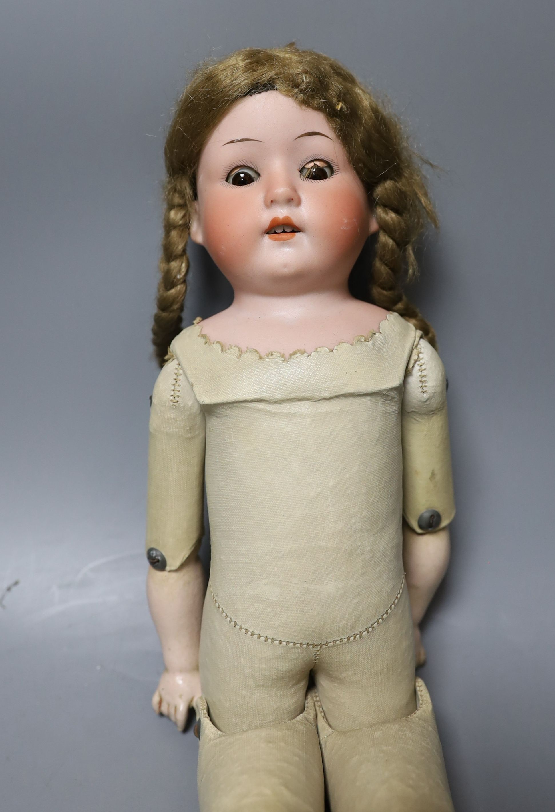A kid leather bodied jointed limb open mouth Heubach bisque headed doll together with two other bisque headed dolls and a boy doll (damaged)